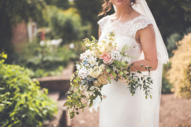 An escaping pastel bridal bouquet with pink roses, pastel stocks, blue love in a mist and cascading foliage. For Emily at Sherbourne Park, Warwickshire. Bouquet by Tuckshop Flowers, Birmingham.